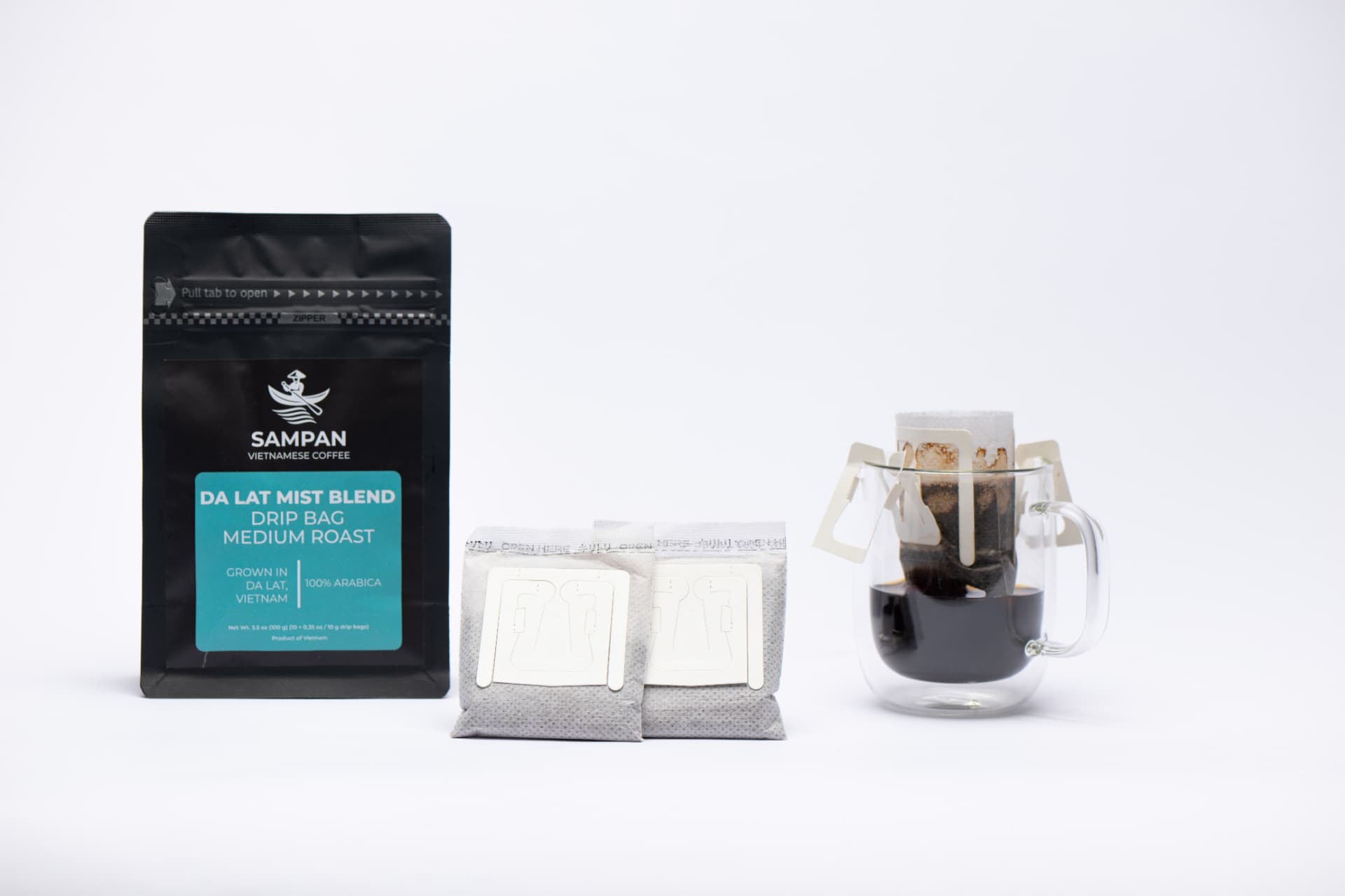 Sampan drip-bag format overview: a coffee bag, individual sachets, and a freshly brewed cup arranged together